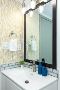 uma casa de banho com um lavatório e um espelho em Cozy 2BR Guest Suite in Leduc 12 Mins to YEG em Leduc