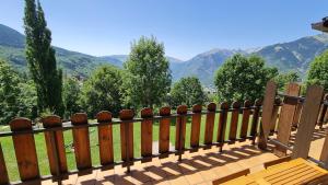 a wooden bench with a view of mountains at tuhogarencerler,sol y vistas in Cerler