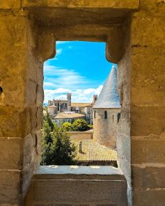 een uitzicht op de stad door een stenen raam bij un gîte dans la cité in Carcassonne
