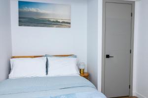 um quarto com uma cama com uma fotografia na parede em Cozy 2BR Guest Suite in Leduc 12 Mins to YEG em Leduc