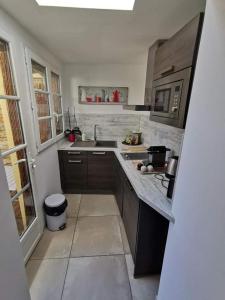 a kitchen with a sink and a microwave at un gîte dans la cité in Carcassonne