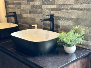 a bathroom with a black tub and a sink at THE ROOM Capsule Hotel in Singapore