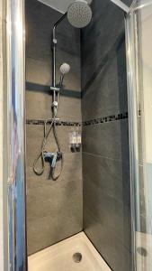 y baño con ducha con cabezal de ducha. en La Tropicale de Croix - Chambre d'Hôtes, en Croix