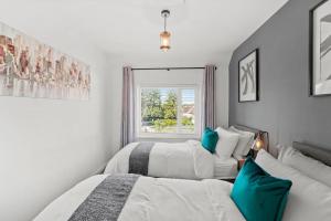 2 łóżka w białym pokoju z oknem w obiekcie Spacious 2 bedroom house with parking & WiFi w mieście Kent