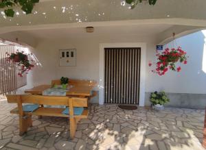 a patio with a wooden table and a bench at Apartman CELIJA in Barban