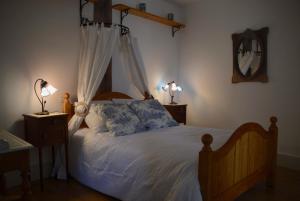 a bedroom with a bed with a canopy and two lamps at Cottage Mackinley, séjour convivial, jeux, grand sapin de Noël, et contes,15 pers, Centre Historique, gare TER in Aubigny-sur-Nère