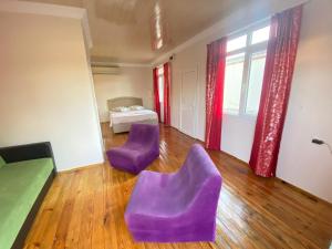 Pokój z 2 fioletowymi krzesłami i łóżkiem w obiekcie Reds Bungalow w mieście Didim
