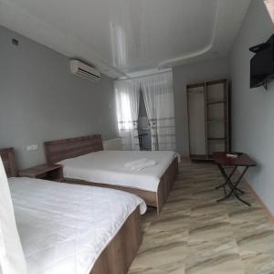a hotel room with two beds and a television at Anna 2 in Kobuleti