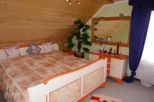 a bedroom with a large bed in a wooden room at Ferienwohnung Bimmelbahn-Blick in Neudorf