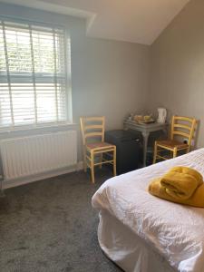 a bedroom with a bed and two chairs and a table at Country House and Spa in Coleraine