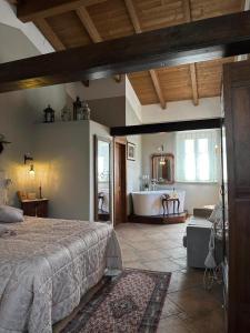 a bedroom with a bed and a bathroom with a tub at Locanda Antico Casale Cesenatico in Cesenatico
