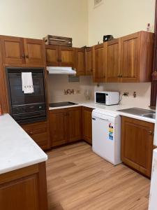 a kitchen with wooden cabinets and white appliances at 122 on Charlotte in Cooktown
