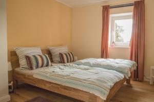 a bedroom with a bed with pillows and a window at Die Ferienwohnungen Schmiede und Gudd Stuvv in Annis Haus in Wadern