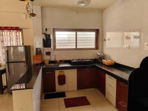 a kitchen with a sink and a refrigerator at Villa with valley view Panhala in Panhāla