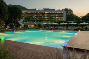 a large swimming pool in front of a hotel at Sheraton Lake Como Hotel in Como