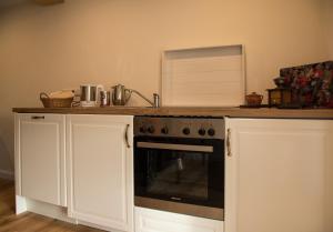 a kitchen with a stove and a counter top at Die Ferienwohnungen Schmiede und Gudd Stuvv in Annis Haus in Wadern