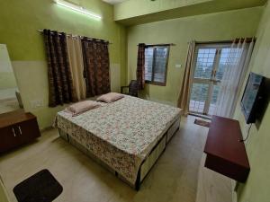 um quarto com uma cama e uma televisão em Villa with valley view Panhala em Panhāla