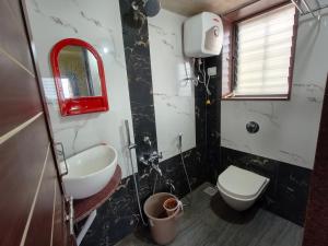 a bathroom with a sink and a toilet and a mirror at Sai Tara Residency - Villa in Panhāla