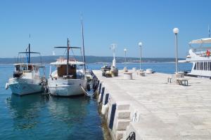 two boats docked at a dock in the water at Apartments Kuća Grško in Selce