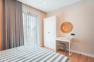 a bedroom with a bed and a desk and a window at Bodrum Local House in Bodrum City