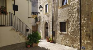 Casa di Principe - Piazza في Lettomanoppello: زقاق به نباتات الفخار ومبنى