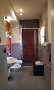 łazienka z 2 toaletami, umywalką i prysznicem w obiekcie Casa di Principe - Piazza w mieście Lettomanoppello