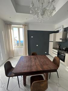 een keuken met een houten tafel en stoelen en een kroonluchter bij Maison Nisco in Ercolano