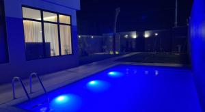 a swimming pool with blue lights in a house at night at شاليه خاص فندقي و مستقل in Riyadh