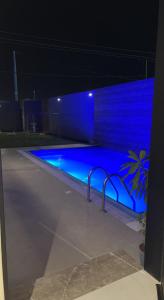 a swimming pool lit up in blue at night at شاليه خاص فندقي و مستقل in Riyadh