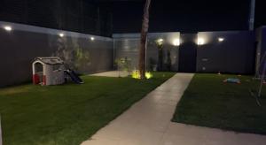 a backyard at night with a lawn with a sidewalk at شاليه خاص فندقي و مستقل in Riyadh