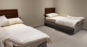 two beds sitting in a room with white walls at شاليه خاص فندقي و مستقل in Riyadh