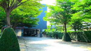 a sidewalk with trees in front of a building at Nest n Rest Hotel in Ban Bang Toei (1)