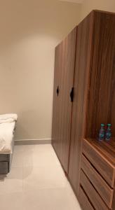 a bedroom with a wooden cabinet next to a bed at شاليه خاص فندقي و مستقل in Riyadh