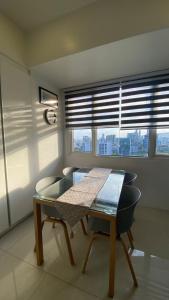 a table and chairs in a room with a window at Calyx Residences 18i in Cebu City