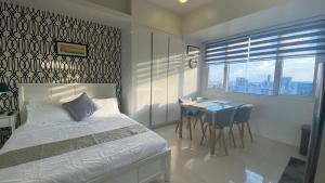 um quarto com uma cama, uma mesa e uma secretária em Calyx Residences 18i em Cebu