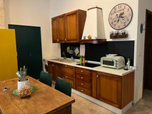 a kitchen with a table and a clock on the wall at La Casa di Pam in Bisceglie