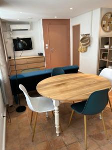 uma sala de estar com uma mesa de madeira e cadeiras em Appartement coeur de ville -Clim, ascenseur, wifi- em Avignon