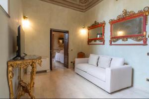 un soggiorno con divano bianco e TV di Casa Matilde a Montepulciano