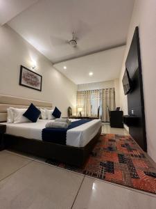 um quarto com uma cama grande e uma televisão em JB Residency Zirakpur !! Top Rated & Most Awarded Property in Zirakpur em Zirakpur