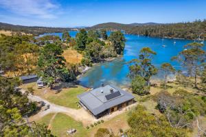 une vue aérienne d'une maison à côté d'un plan d'eau dans l'établissement 'Questa' Heritage Cottage, à Barnes Bay 24 autres photos