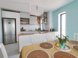 Chiajna的住宿－Penthouse panoramic，一间带桌椅的厨房和一间用餐室