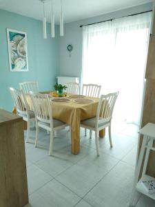 stół jadalny z białymi krzesłami, stół i szezlong w obiekcie Penthouse panoramic w mieście Chiajna