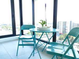 a table and two chairs in a room with windows at Penthouse panoramic in Chiajna