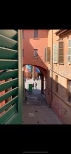 Blick auf eine Gasse mit einem Torbogen zwischen zwei Gebäuden in der Unterkunft Backpackers House in Bologna