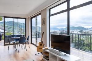 a living room with a large television and a table and chairs at Firkins Retreat, Picton in Picton