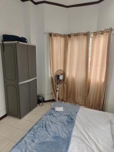 1 dormitorio con 1 cama con ventilador y ventana en Best Inn Lahug, en Cebú