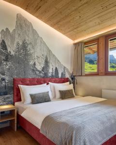 a bedroom with a large bed with a painting on the wall at Appartamenti Les Viles in La Villa