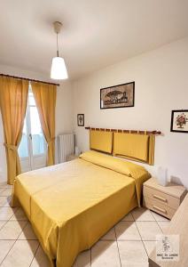 a bedroom with a yellow bed in a room at Made in Langhe Apartment in La Morra