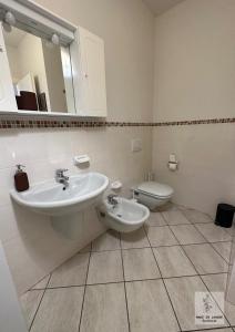 La salle de bains est pourvue d'un lavabo et de toilettes. dans l'établissement Made in Langhe Apartment, à La Morra