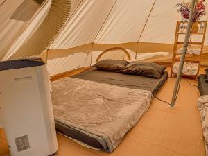 a bed in a tent in a room at MUINE SUN & SEA BEACH ( BOUTIQUE RESORT & GLAMPING) in Mui Ne